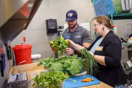 SARC and Eagle Dining staff inspect a produce delivery in the kitchen
